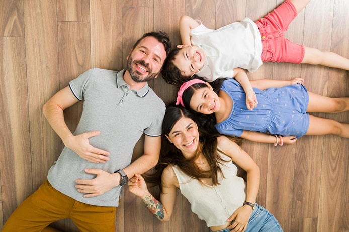 Happy Family Lying on Hardwood Floors